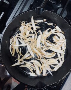 Onion slices frying in a cast iron skillet 