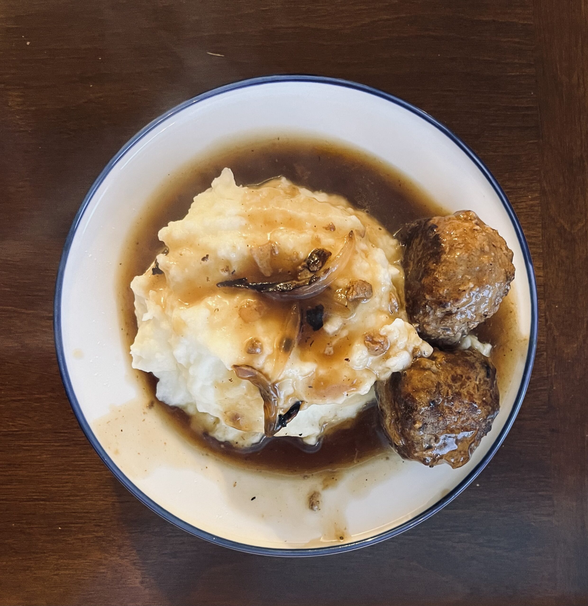 mashed potatoes covered with gravy and maetballs
